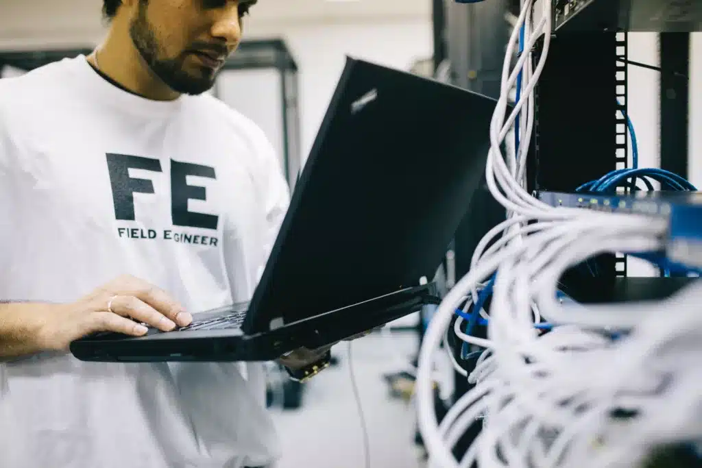 Man working on a laptop behind a server, representing website revamp services.